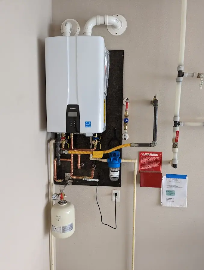 Professional plumber installing copper piping in a Coweta home